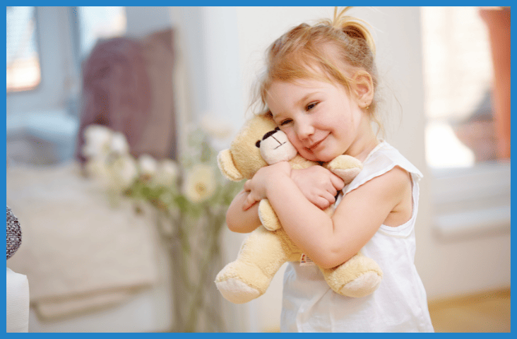 Toys from home – what is their place at Mother Duck blog feature image of a young girl with a teddy